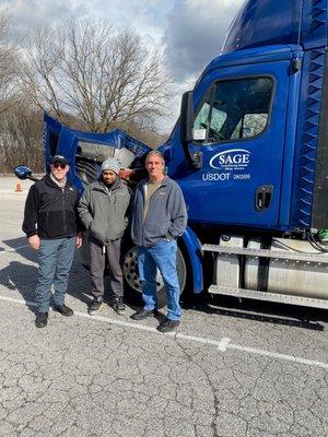 Sage students and faculty posing in front of training truck.