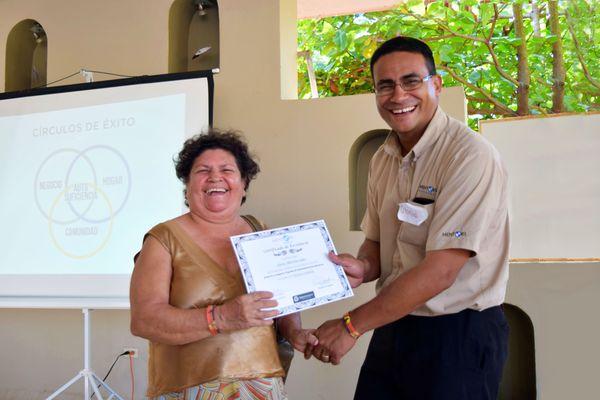 Picture of a women graduating from the business training classes from Mentors International.