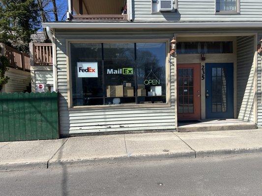 Store front, FedEx sign, MailEx sign and boxes in display.