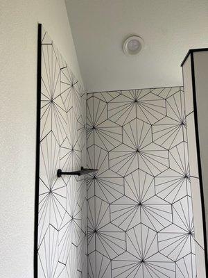 Intricate shower tile work along with remodeling of the floor and shower glass