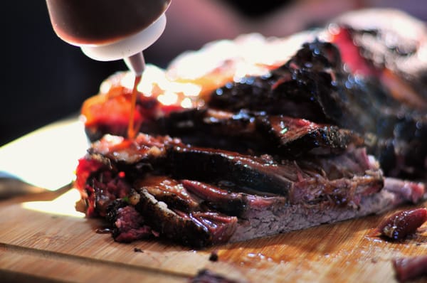 The chef adding sauce to the Brisket