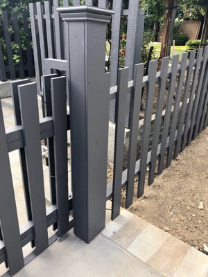 Metal fabricated rolling mechanical drive gate with redwood stained cladding