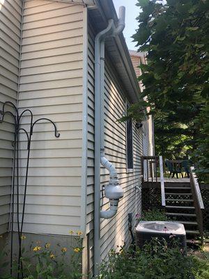 Radon fan placed near gutter spout to blend in.