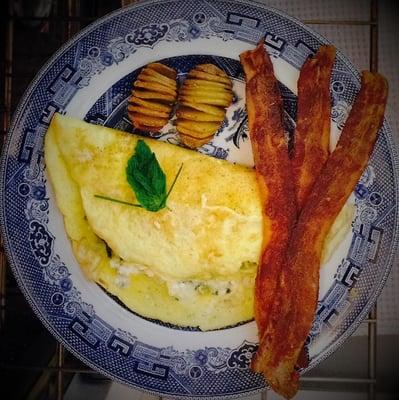 Spinach Tomato Feta Omelet with hassle back baked potatoes and crisp bacon.