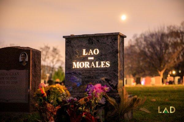 Morales' granite tombstone illuminating as the sun sets.