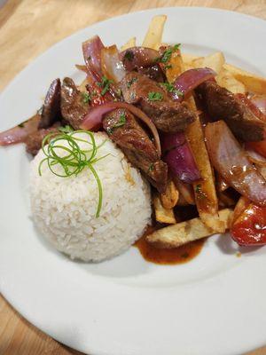 Lomo saltado, with pieces of beef tenderloin, tomato and onion, served with crispy french fries and grained rice.