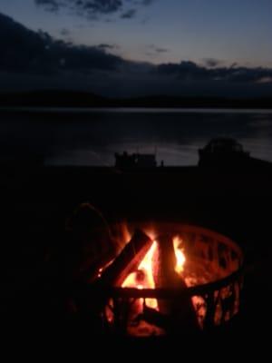 Pic of the fire pit--shared by all the guests, on a concrete patio, log benches surrounding it, wood already split, ahhh...