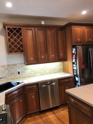 Before photo. Kitchen cabinet color change from dark wood stain to white.