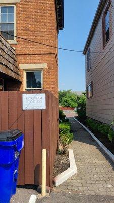 View of the walkway to the from of the building from the parking lot where you park