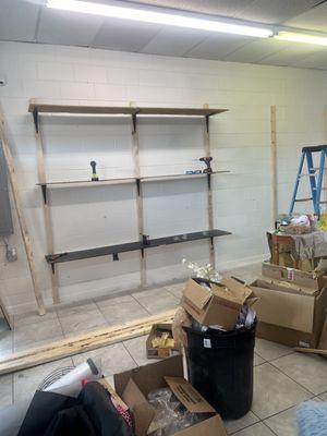 This picture captures the initial stages of installing shelves in a store. The client requested that we utilize existing materials to reduce