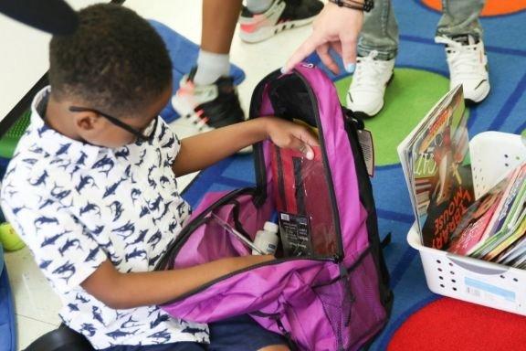 Student receiving a supply-filled backpack form the Junior League of Columbus's Adopt-a-Backpack for Children (ABC) Project.