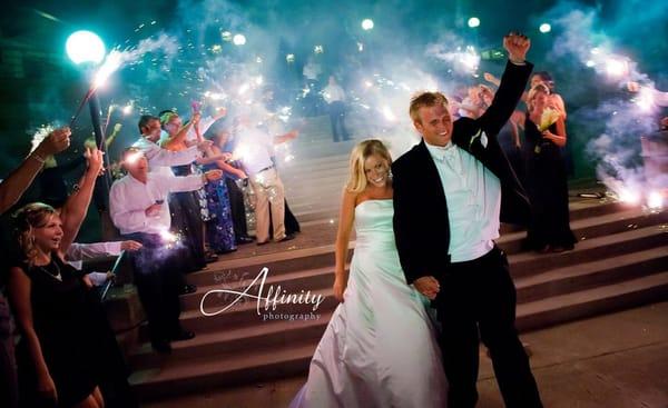 Bride and groom depart their Woodmark Hotel wedding reception flanked by their friends and family with sparklers.