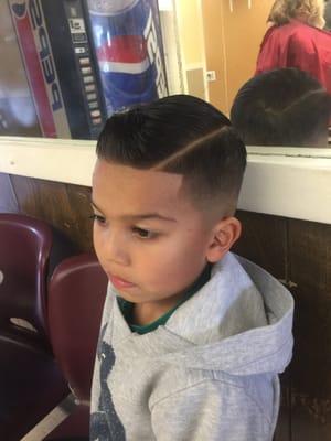 Jose getting down with a medium fade with side part and line up.