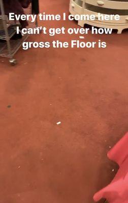 Gross floor, notice the empty shelving in the back and the weird wire cart with product on it