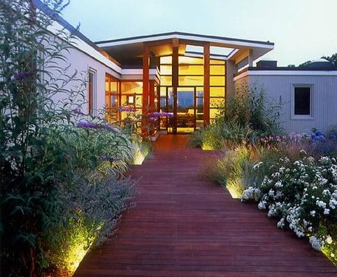 Raised wooden boardwalk for home with an ocean-view; beach plantings of grasses, butterfly bush, hydrangeas, daylilies and roses