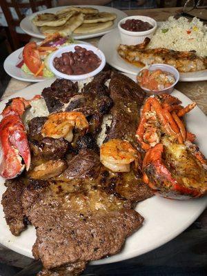 El apretador sprecial. Steak with half a lobster and shrimp over rice and beans