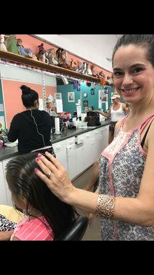 Removing head lice from a little girl.