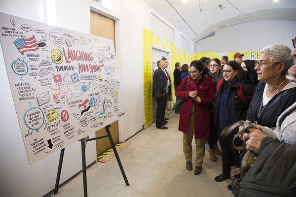 A crowd views visual notes drawn at a Chicago Ideas conversation.