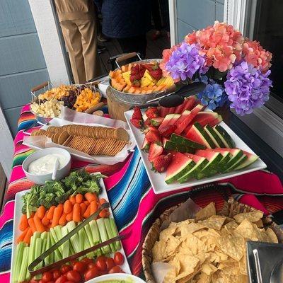 Appetizers station with fresh fruit veggies and cheese.