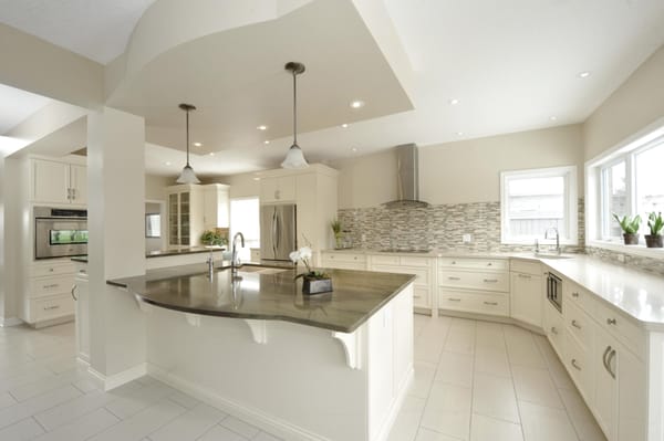 Contemporary, spacious white kitchen with traditional elements.  Large center island with second sink, additional prep space & ample seating