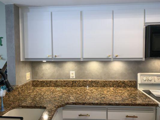 Beautiful plastered kitchen wall with white cabinets