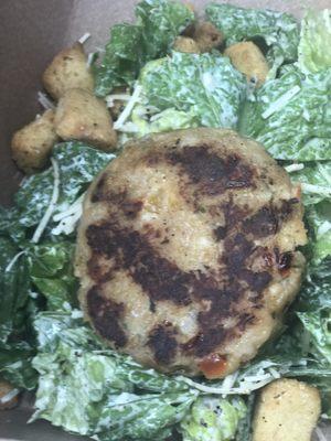 Caesar Salad with a twist topped with homemade crab cake and garlic aioli dressing.