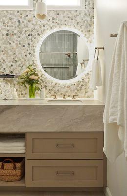 Waterfall edge counter top, marble mosaic backsplash and specialty lighting make this guest bath both functional and beautiful.