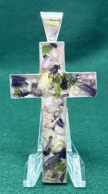 This beautiful cross with funeral flowers encased in resin.
 Can be worn as a necklace or as an ornament for your holiday tree.