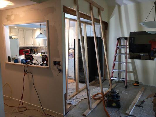 Removed portion of kitchen wall installed header twice the size of existing to allow cabinet and counter to push into room.