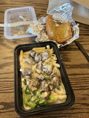 Alfredo steak and broccoli pasta w some garlic bread. In a to go plate