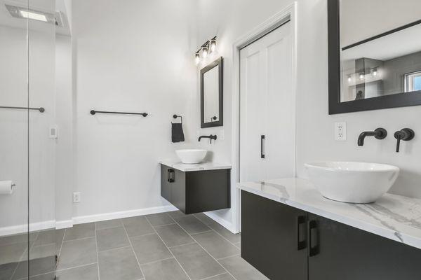 Modern master bath remodel at Lake Springfield. Tiled shower, built in bench, linear drain, doorless entry. Floating vanities, vessel sinks.