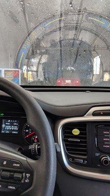 Attendant sprays and scrubs down the car then sprays again before the machine. Impressive.