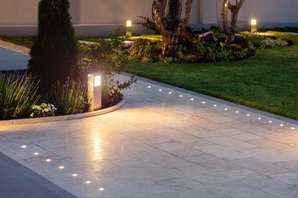 Pathway lights with travertine. Lights are colored changing and is app controlled.