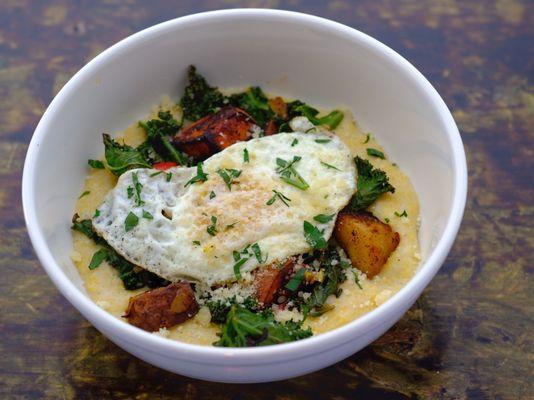 Hangover Bowl with sauteed kale, roasted potato hash, fried egg & parmesan cheese over grits.