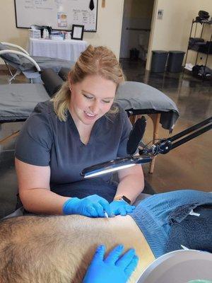 Electrologist performing permanent hair removal on man's back