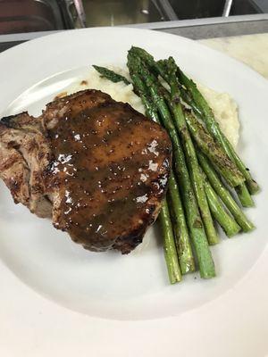 Porterhouse Porkchop topped with a honey mustard stout, grilled asparagus and garlic mashed potatoes