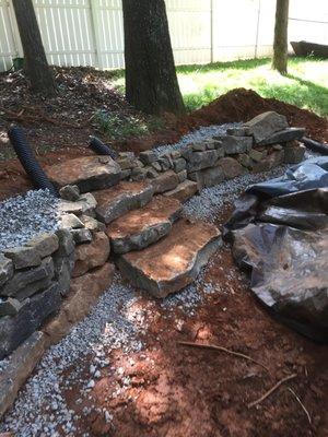 Rock wall, patio, fire pit, water fall, fountain, koi pond, pond, sod, garden walk, walking path, back yard, boulder wall, hardscape