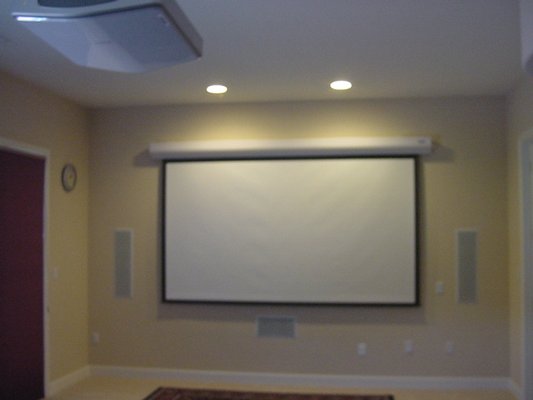 Singh home theater with motorized screen, in-wall speakers, projector