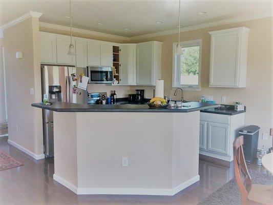 White kitchen cabinets and raised bar top island