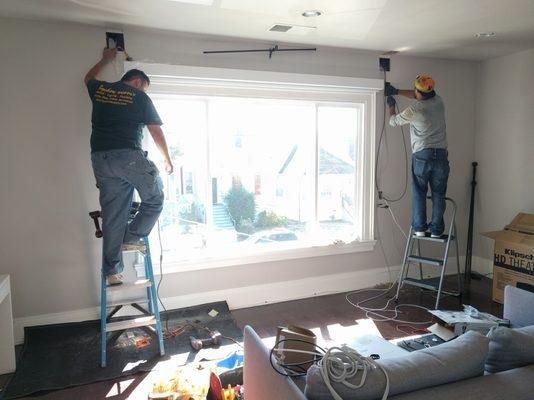 Running the wiring necessary for wall-mounted speakers and a subwoofer.