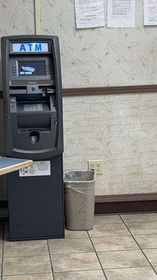 ATM to left of door near chairs for waiting on laundry