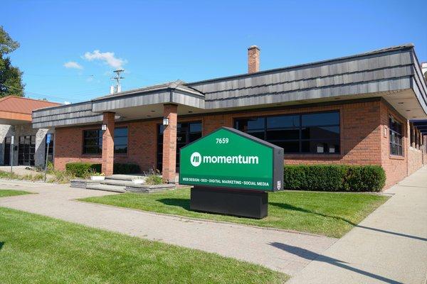 Exterior of Momentum, a digital marketing agency, offices in Utica, Mi with green and white signage