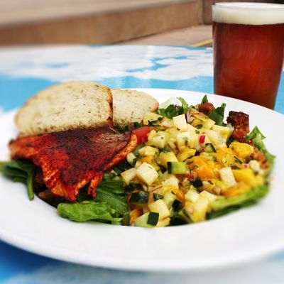 Grilled Salmon Salad made with fresh salmon, blackened in Cajun seasoning blend topped with fresh mango salsa served over a garden salad.