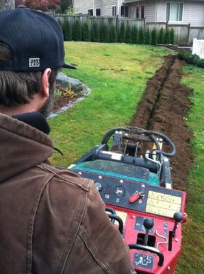 Trenching for a drainage system installation.