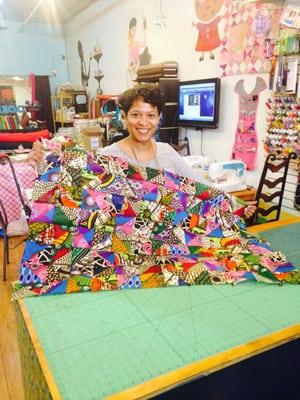 Tonya happy to display her first finished African Ankara fabric quilt for her couch! Great job Tonya!