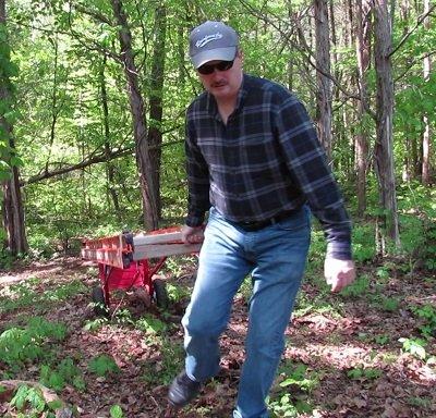 Pulling a heavy ladder through wooded rough terrain.