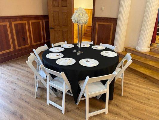 Decoración con centro de mesa, platos, cubiertos, mantel, y silla de resina