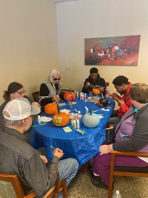 Staff and participants painting pumpkins to donate to the Hospital for Special Care at one of our Change Inc. offices!