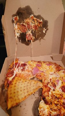 Crushed box, flipped pizza, cheese n toppings stuck to the box.