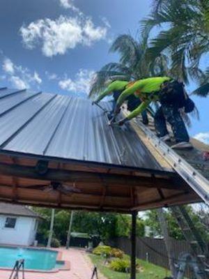 Guys installing panels with a chicken ladder  on our first Tiki Hut